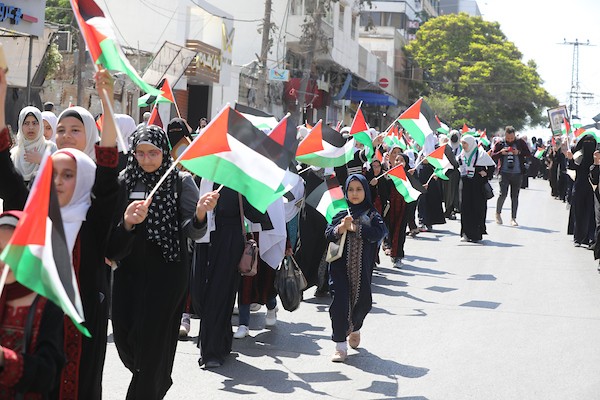 فلسطينيات يشاركن في مسير الأعلام الفلسطينية خلال انطلاق مخيمات مواكب سيف القدس القرآنية في مدينة غزة 6.jpg