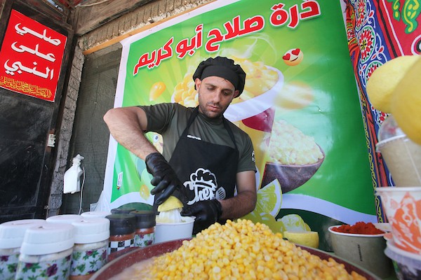 صلاح الخولي يتفنن في ابتكار طرق جديدة لبيع الذرة داخل كشك صغير وسط مدينة غزة 5.jpg
