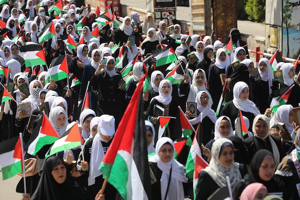 فلسطينيات يشاركن في مسير الأعلام الفلسطينية خلال انطلاق مخيمات مواكب سيف القدس القرآنية في مدينة غزة.jpg