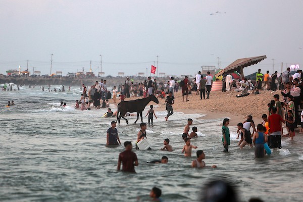 المواطنون الفلسطينيون يصطافون على شاطئ بحر مدينة غزة خلال يوم العطلة 4.jpg