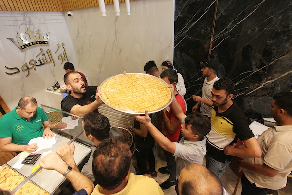 فلسطينيون يشترون الحلويات بعد ظهور نتائج الثانوية العامة في مدينة غزة.jpg