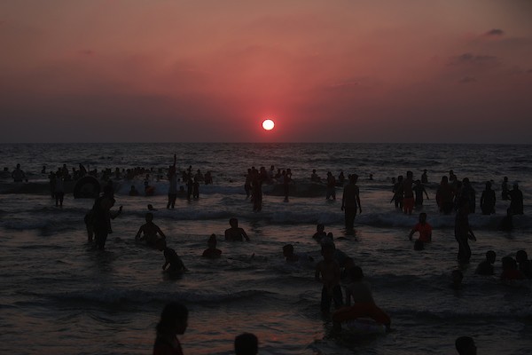 المواطنون الفلسطينيون يصطافون على شاطئ بحر مدينة غزة خلال يوم العطلة 1.jpg