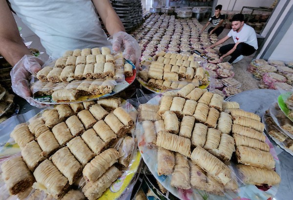 فلسطينيون يجهزون الحلويات داخل أحد المصانع استعدادا لنتائج الثانوية العامة في مدينة خانيونس 8.jpg