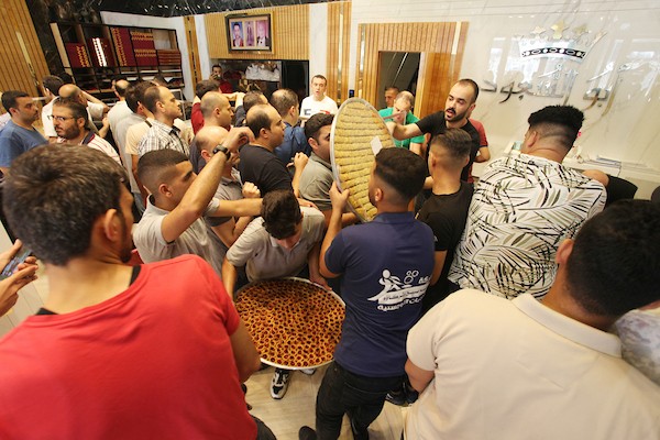 فلسطينيون يشترون الحلويات بعد ظهور نتائج الثانوية العامة في مدينة غزة 11.jpg