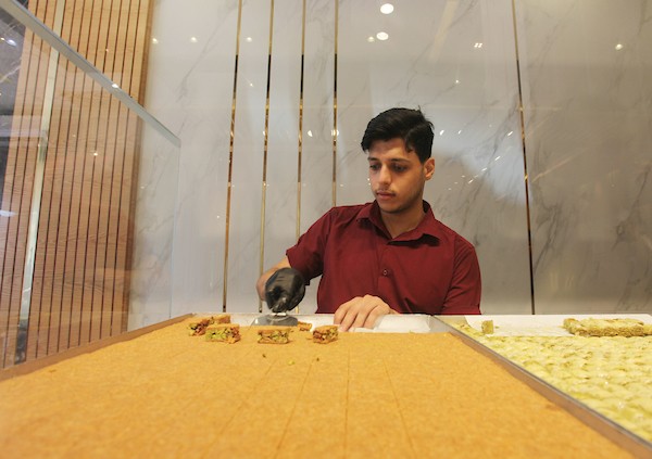 فلسطينيون يشترون الحلويات بعد ظهور نتائج الثانوية العامة في مدينة غزة 5.jpg