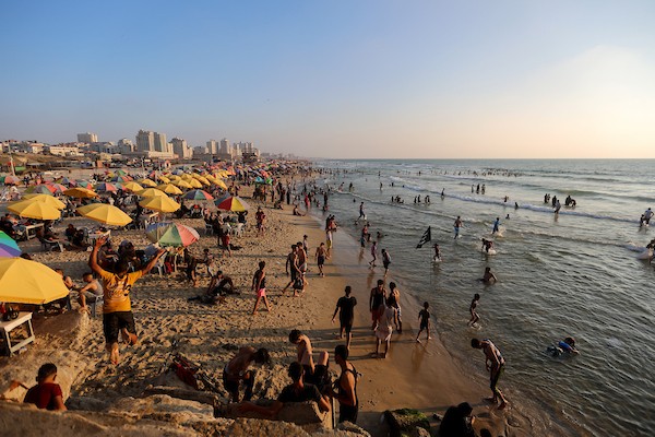 المواطنون الفلسطينيون يصطافون على شاطئ بحر مدينة غزة خلال يوم العطلة.jpg