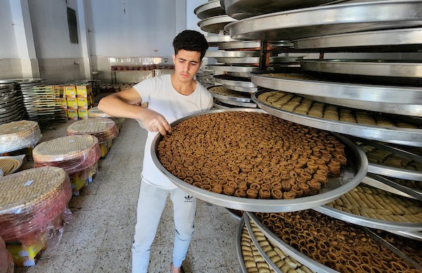 فلسطينيون يجهزون الحلويات داخل أحد المصانع استعدادا لنتائج الثانوية العامة في مدينة خانيونس 5.jpg