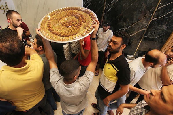 فلسطينيون يشترون الحلويات بعد ظهور نتائج الثانوية العامة في مدينة غزة 2.jpg