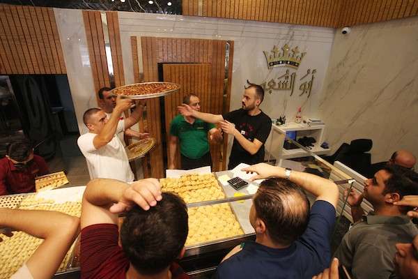 فلسطينيون يشترون الحلويات بعد ظهور نتائج الثانوية العامة في مدينة غزة 4.jpg