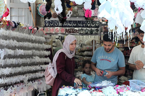 فلسطينيون يتسوقون استعداداً لاستقبال العام الدراسي الجديد في مخيم جباليا شمال قطاع غزة 14.jpg