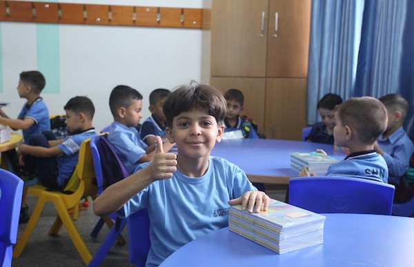 طلاب فلسطينيون يستلمون القرطاسية المدرسي في اليوم الأول من العام الدراسي الجديد في مدرسة تابعة لوكالة الغوث في مدينة غزة 6.jpg