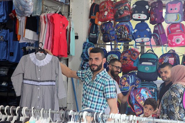 فلسطينيون يتسوقون استعداداً لاستقبال العام الدراسي الجديد في مخيم جباليا شمال قطاع غزة 21.jpg