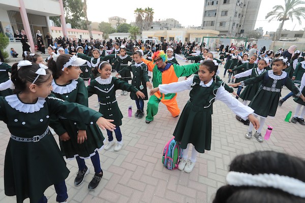 مهرجون فلسطينيون يشاركون في فعاليات التفريغ النفسي للطلبة خلال اليوم الأول من العام الدراسي الجديد في مدينة خان يونس جنوب قطاع غزة 13.jpg