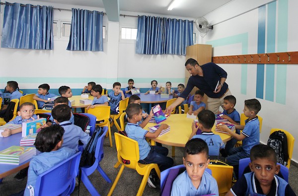 طلاب فلسطينيون يستلمون القرطاسية المدرسي في اليوم الأول من العام الدراسي الجديد في مدرسة تابعة لوكالة الغوث في مدينة غزة 3.jpg