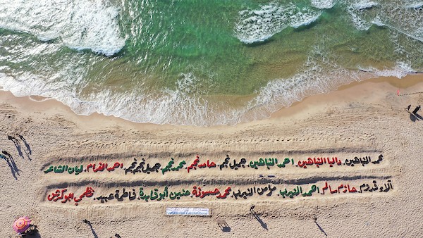 صور جوية لمنحوتة رملية على شاطئ غزة تحمل أسماء الشهداء الأطفال.JPG
