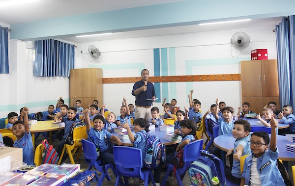 طلاب فلسطينيون يستلمون القرطاسية المدرسي في اليوم الأول من العام الدراسي الجديد في مدرسة تابعة لوكالة الغوث في مدينة غزة 9.jpg