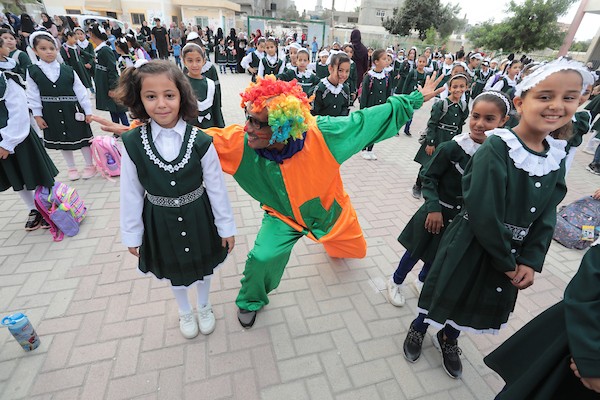 مهرجون فلسطينيون يشاركون في فعاليات التفريغ النفسي للطلبة خلال اليوم الأول من العام الدراسي الجديد في مدينة خان يونس جنوب قطاع غزة 2.jpg
