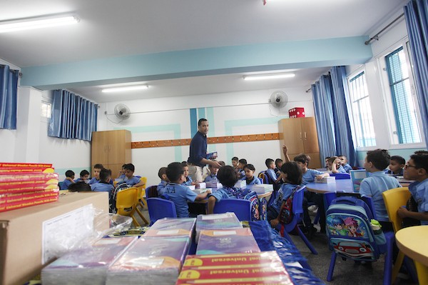 طلاب فلسطينيون يستلمون القرطاسية المدرسي في اليوم الأول من العام الدراسي الجديد في مدرسة تابعة لوكالة الغوث في مدينة غزة 7(1).jpg