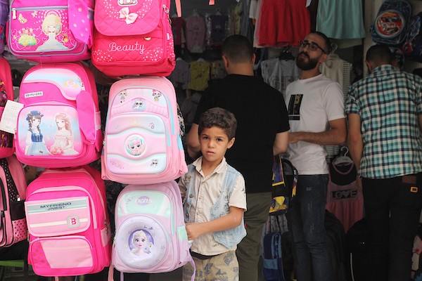 فلسطينيون يتسوقون استعداداً لاستقبال العام الدراسي الجديد في مخيم جباليا شمال قطاع غزة 10.jpg