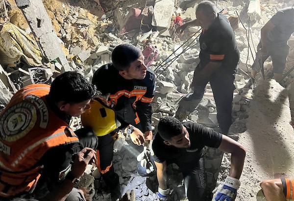 فلسطينيون وطواقم الدفاع المدني تجري عمليات بحث عن ناجين بعد استهداف منزل بغارة جوية إسرائيلية في مدينة رفح.jpg