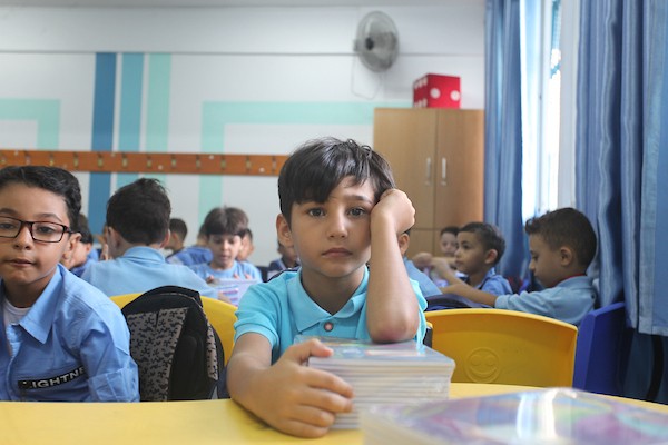 طلاب فلسطينيون يستلمون القرطاسية المدرسي في اليوم الأول من العام الدراسي الجديد في مدرسة تابعة لوكالة الغوث في مدينة غزة 2.jpg