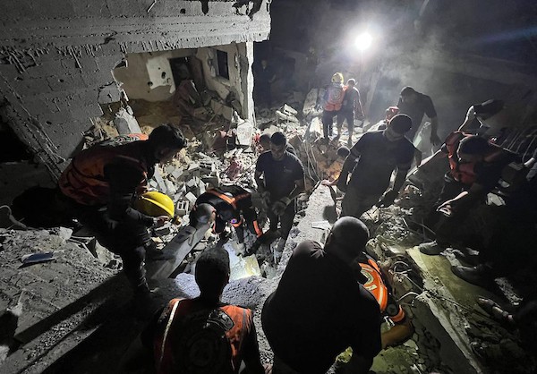 فلسطينيون وطواقم الدفاع المدني تجري عمليات بحث عن ناجين بعد استهداف منزل بغارة جوية إسرائيلية في مدينة رفح 2.jpg