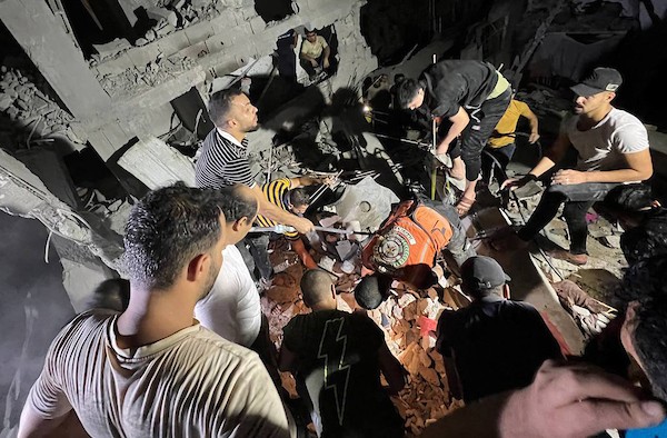 فلسطينيون وطواقم الدفاع المدني تجري عمليات بحث عن ناجين بعد استهداف منزل بغارة جوية إسرائيلية في مدينة رفح 11.jpg