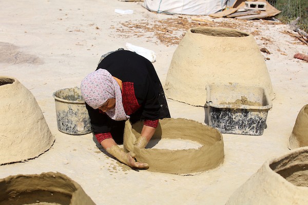 استغلت الفلسطينية آمنة صلاح سطح منزلها لتصنع أفران الطين القديمة بشكل تقليدي، استعداداً لبيعها بالأسواق المحلية في بيت لحم. 1.jpg