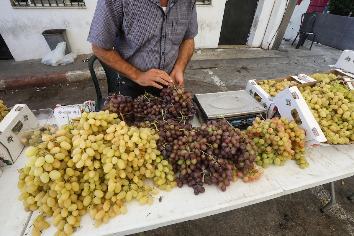 بائعون فلسطينيون يبيعون العنب في سوق للعنب في مدينة رام الله بالضفة الغربية 15.jpg