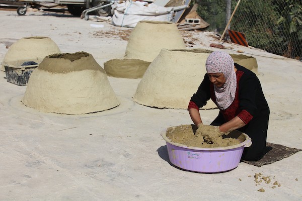 استغلت الفلسطينية آمنة صلاح سطح منزلها لتصنع أفران الطين القديمة بشكل تقليدي، استعداداً لبيعها بالأسواق المحلية في بيت لحم. 6.jpg
