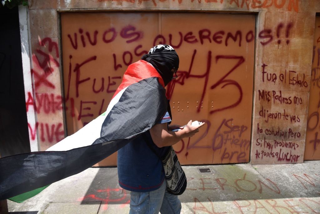 متظاهر أمام السفارة الإسرائيلية في المكسيك، أمس، يرفع العلم الفلسطيني (Getty Images).jpg