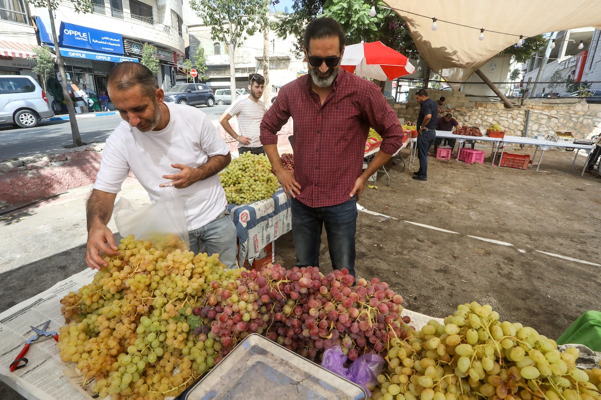 بائعون فلسطينيون يبيعون العنب في سوق للعنب في مدينة رام الله بالضفة الغربية 5.jpg