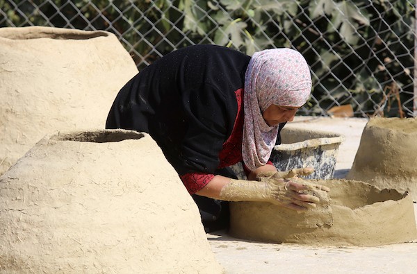 استغلت الفلسطينية آمنة صلاح سطح منزلها لتصنع أفران الطين القديمة بشكل تقليدي، استعداداً لبيعها بالأسواق المحلية في بيت لحم. 14(1).jpg
