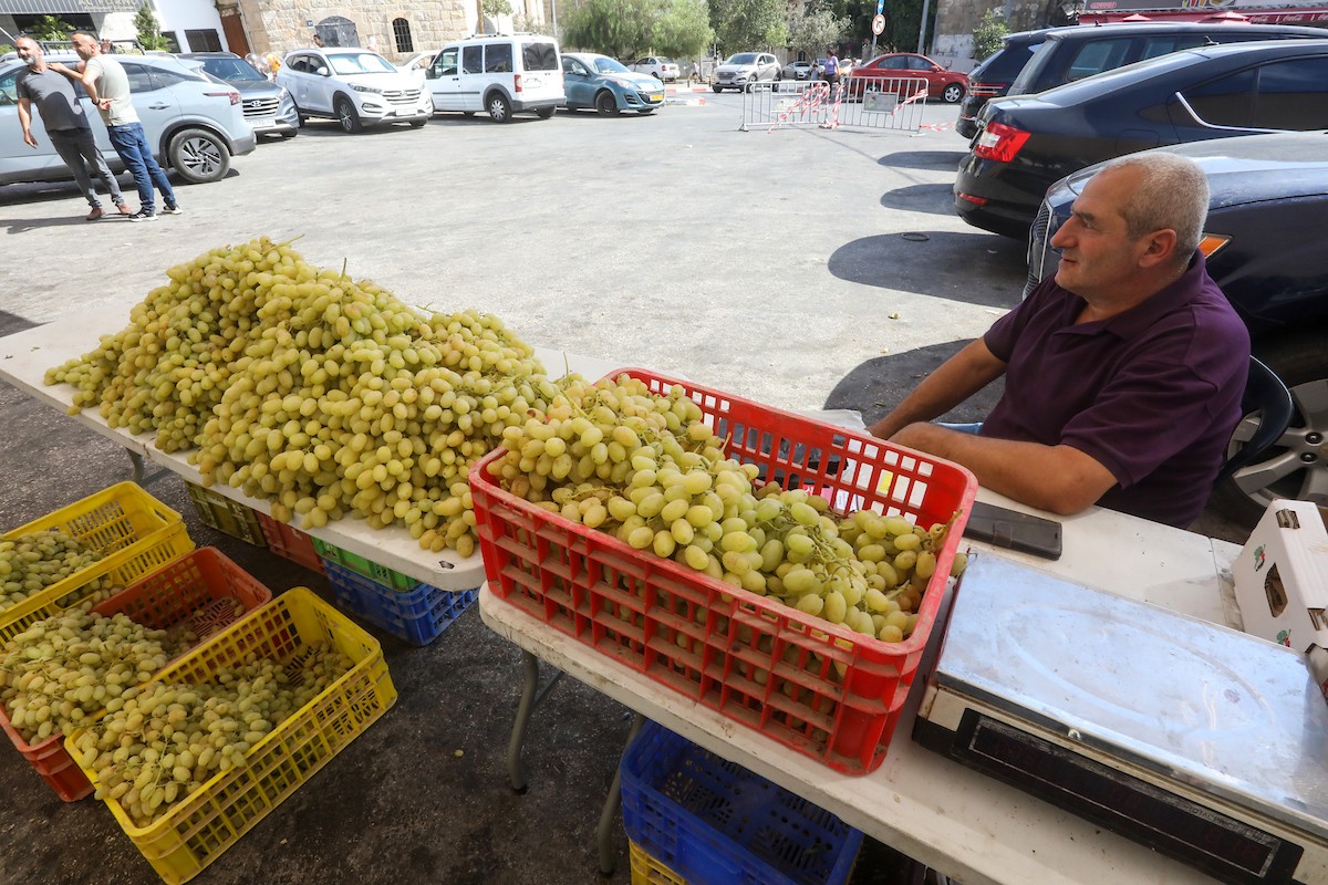 بائعون فلسطينيون يبيعون العنب في سوق للعنب في مدينة رام الله بالضفة الغربية 1.jpg