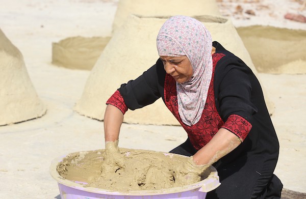 استغلت الفلسطينية آمنة صلاح سطح منزلها لتصنع أفران الطين القديمة بشكل تقليدي، استعداداً لبيعها بالأسواق المحلية في بيت لحم. 12.jpg