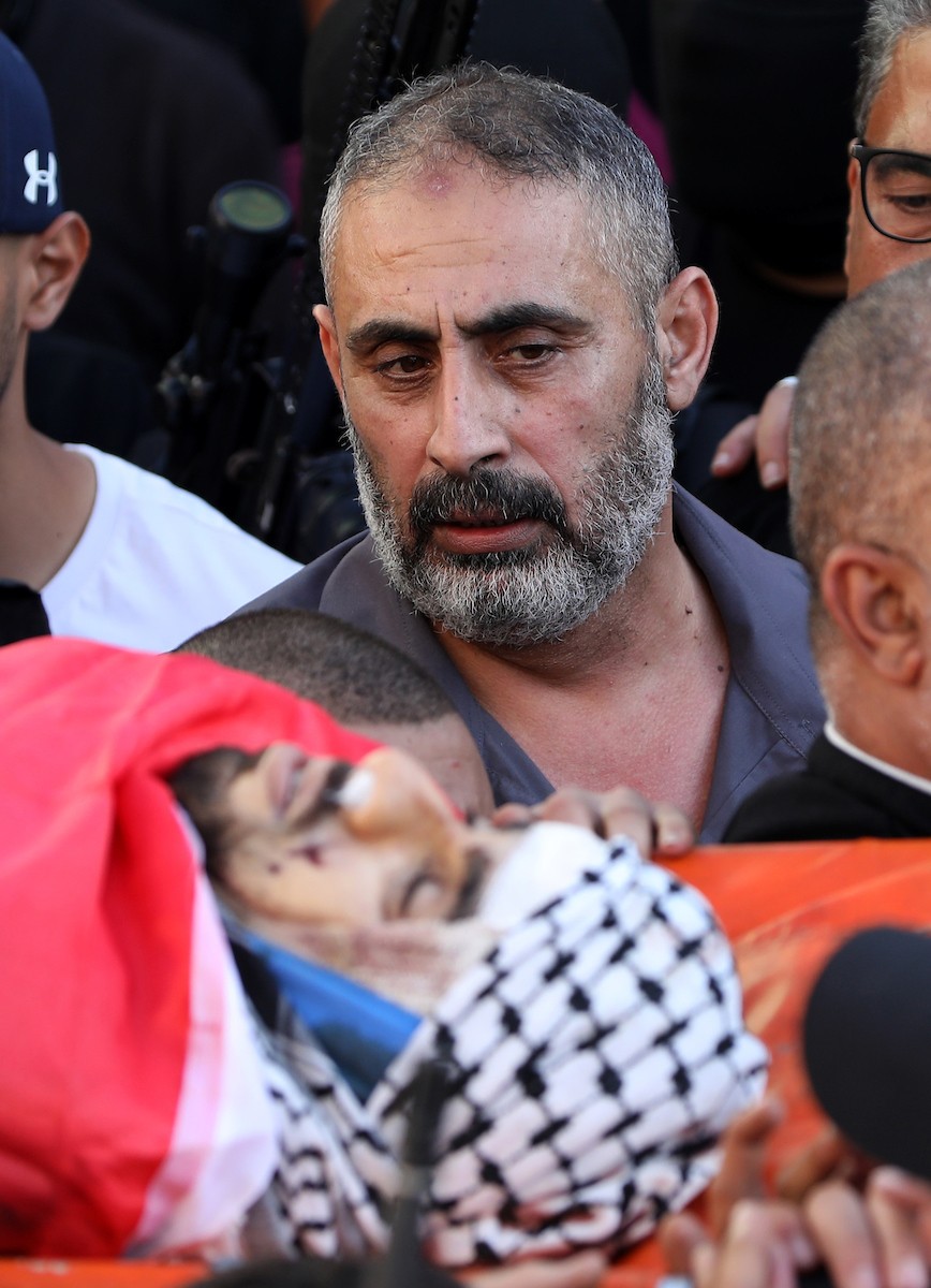 فتحي خازم يودع ابنه الشهيد عبد الرحمن خلال جنازته في مدينة جنين.jpg