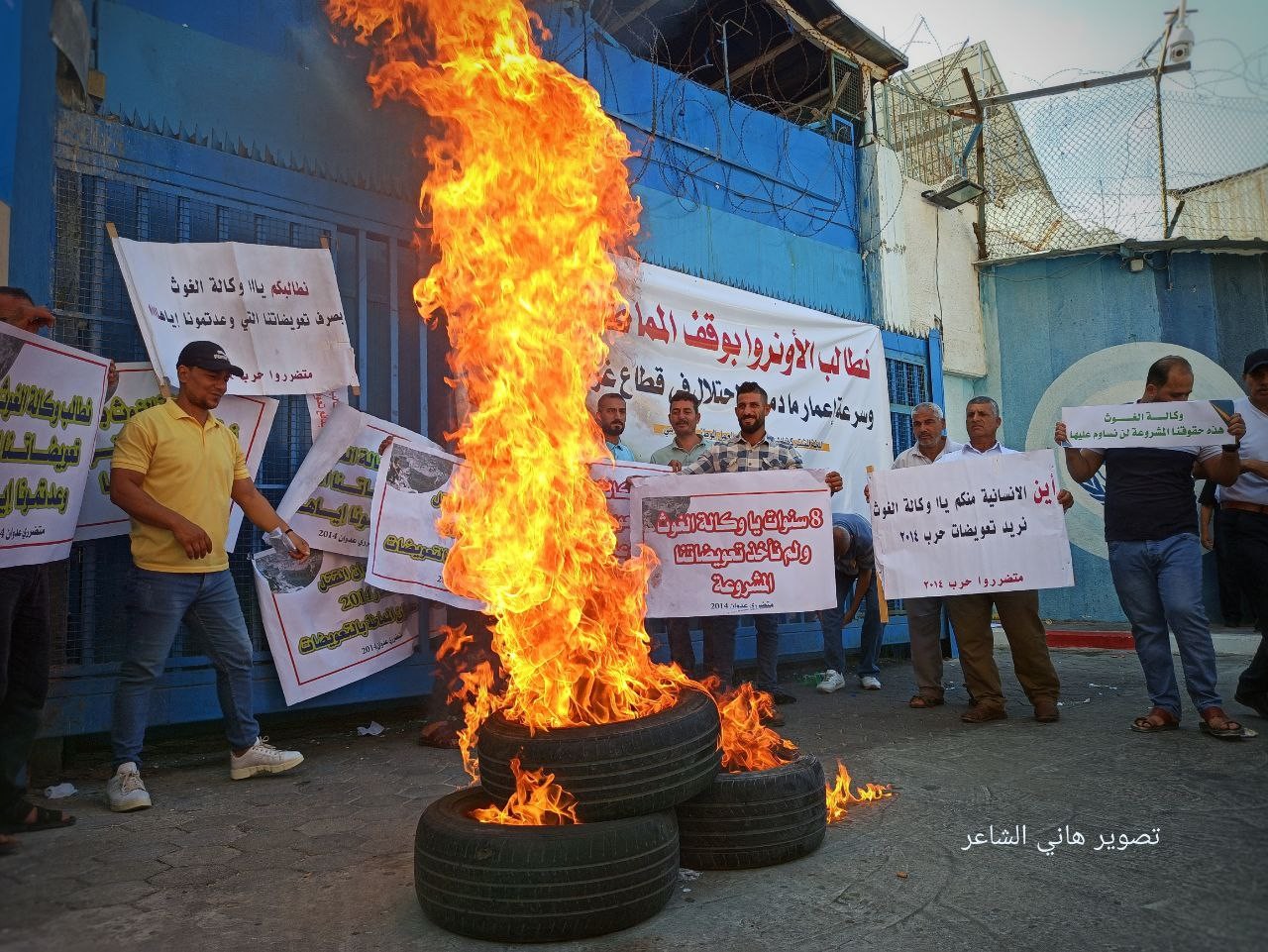 غاضبون يلقون البيض الفاسد ويشعلون إطارات مطاطية أمام بوابة مقر وكالة الغوث الإقليمي بغزة 2.jpg