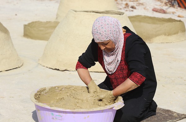استغلت الفلسطينية آمنة صلاح سطح منزلها لتصنع أفران الطين القديمة بشكل تقليدي، استعداداً لبيعها بالأسواق المحلية في بيت لحم. 0.jpg