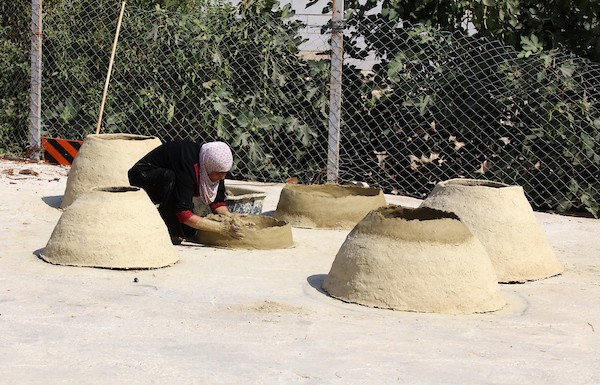 استغلت الفلسطينية آمنة صلاح سطح منزلها لتصنع أفران الطين القديمة بشكل تقليدي، استعداداً لبيعها بالأسواق المحلية في بيت لحم. 22.jpg