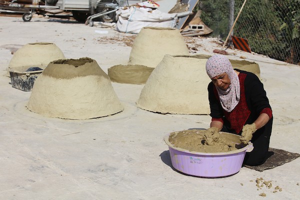 استغلت الفلسطينية آمنة صلاح سطح منزلها لتصنع أفران الطين القديمة بشكل تقليدي، استعداداً لبيعها بالأسواق المحلية في بيت لحم.9.jpg