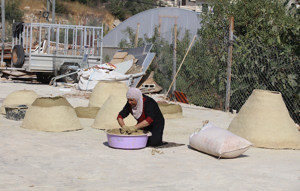 استغلت الفلسطينية آمنة صلاح سطح منزلها لتصنع أفران الطين القديمة بشكل تقليدي، استعداداً لبيعها بالأسواق المحلية في بيت لحم. 5.jpg