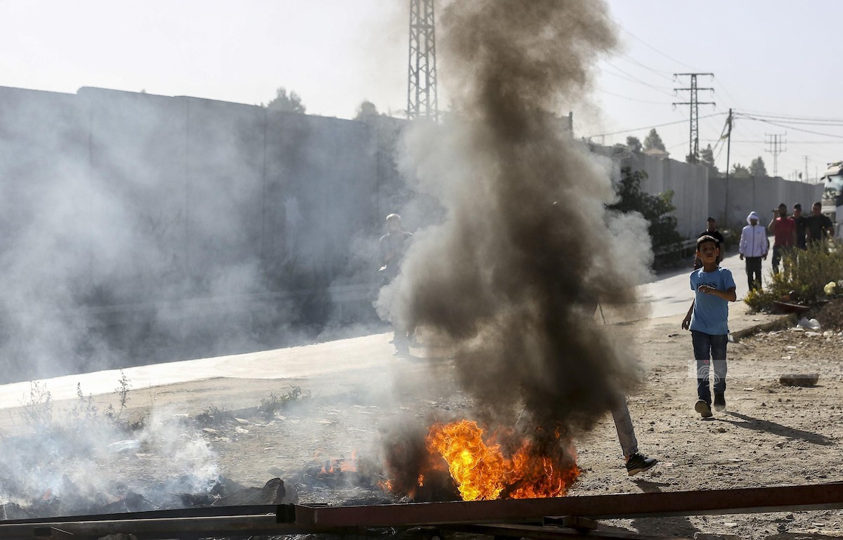 متظاهرون فلسطينيون يشعلون الاطارات عقب استشهاد شابين، في مخيم الجلزون في رام الله 7.jpg