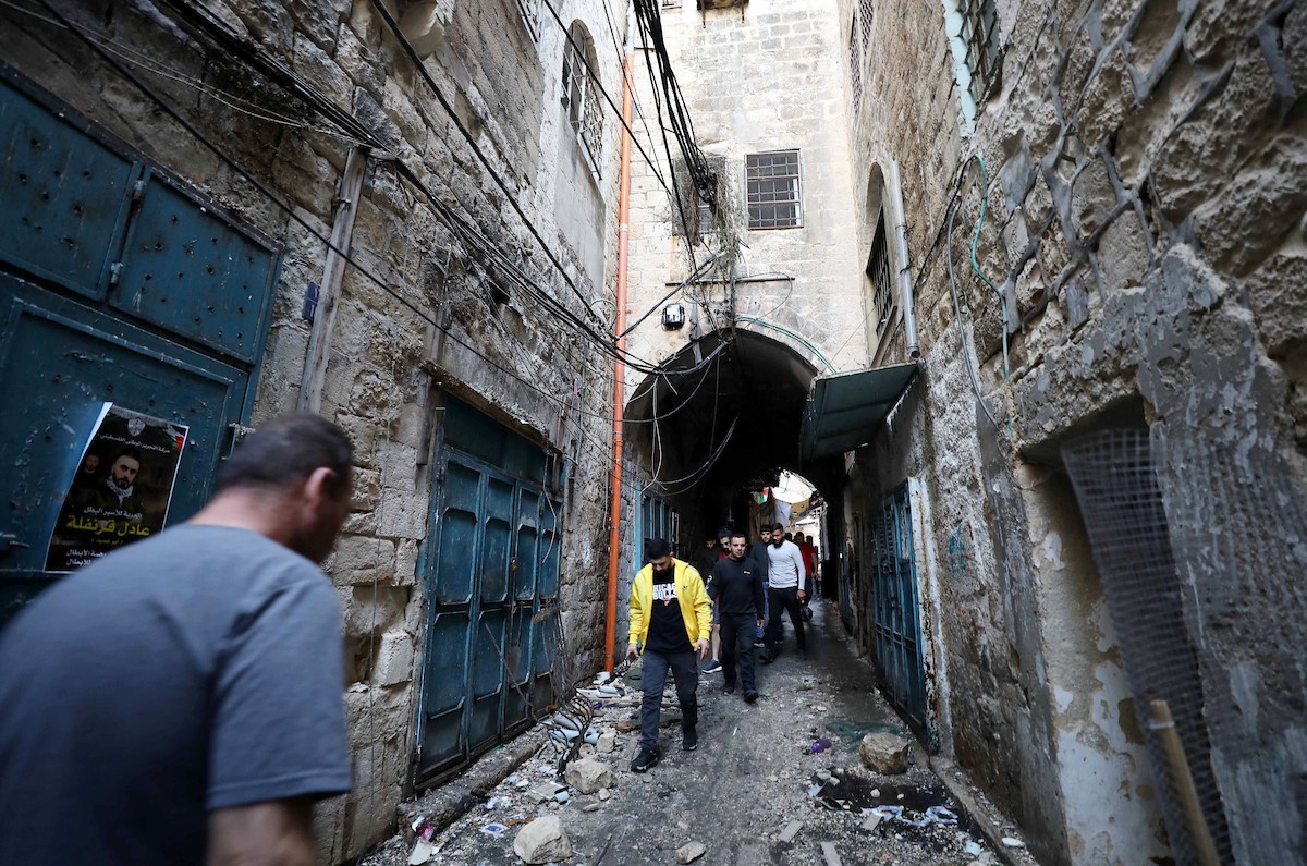 فلسطينيون يتفقدون آثار الدمار الذي لحق بمنزل قصفته قوات الاحتلال في حارة الياسمينة بالبلدة القديمة لمدينة نابلس 5.jpg