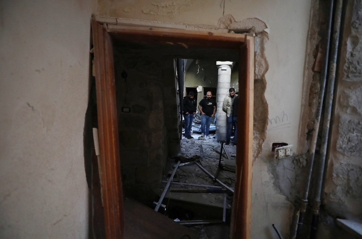 فلسطينيون يتفقدون آثار الدمار الذي لحق بمنزل قصفته قوات الاحتلال في حارة الياسمينة بالبلدة القديمة لمدينة نابلس ث.jpg