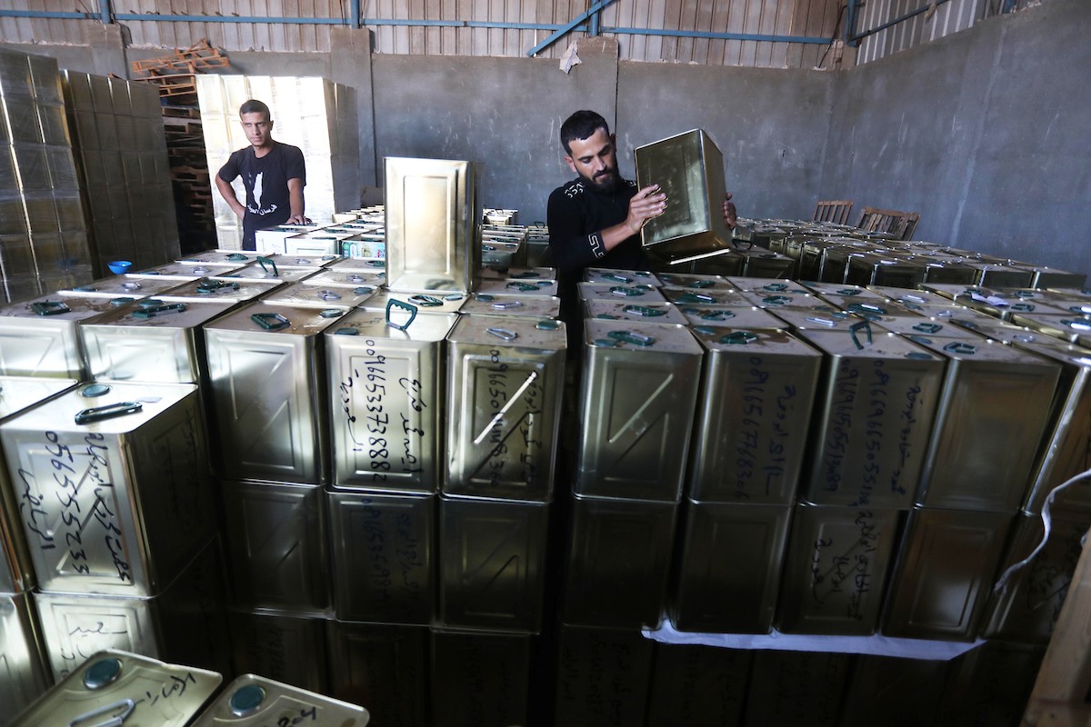 عمال فلسطينيون يجهزون صفائح زيت الزيتون لتصديرها لدول الخليج في مدينة خان يونس جنوب قطاع غزة 16.jpg