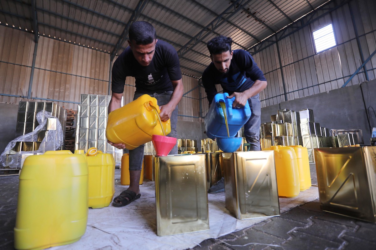 عمال فلسطينيون يجهزون صفائح زيت الزيتون لتصديرها لدول الخليج في مدينة خان يونس جنوب قطاع غزة 7.jpg
