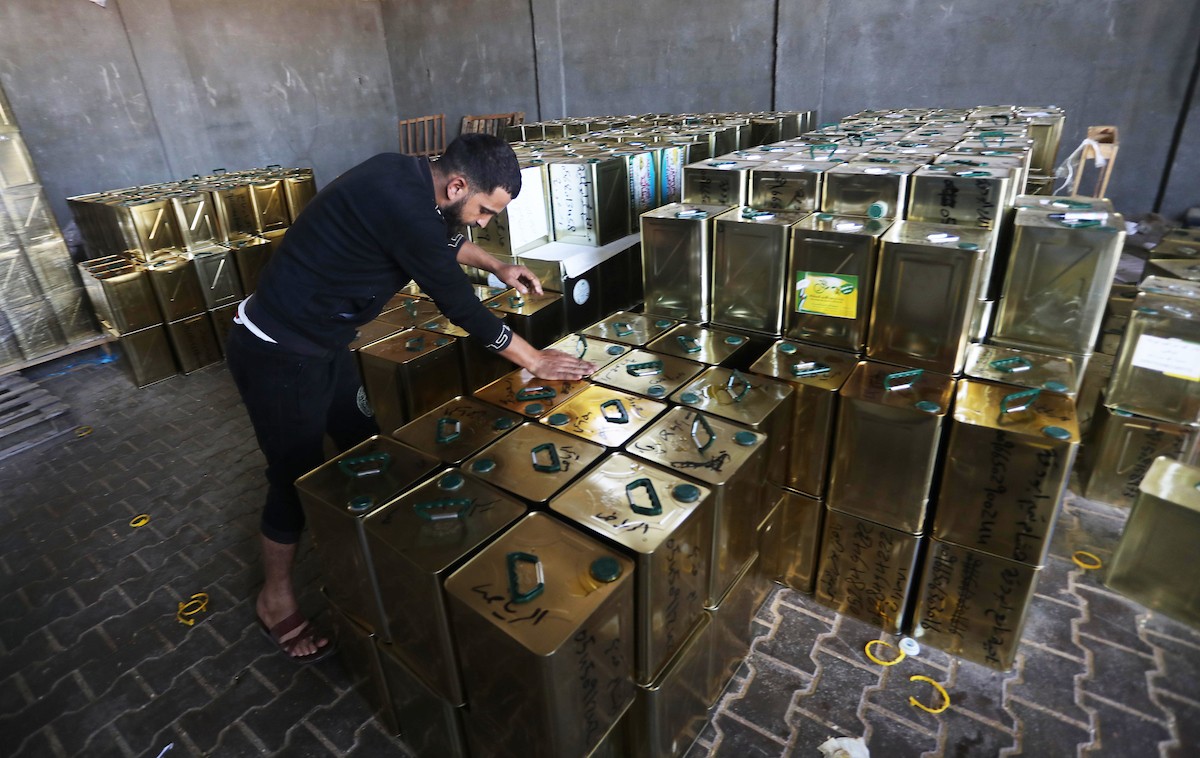 عمال فلسطينيون يجهزون صفائح زيت الزيتون لتصديرها لدول الخليج في مدينة خان يونس جنوب قطاع غزة 8.jpg