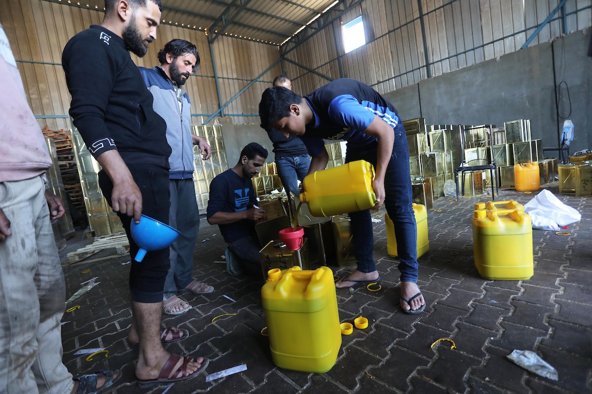 عمال فلسطينيون يجهزون صفائح زيت الزيتون لتصديرها لدول الخليج في مدينة خان يونس جنوب قطاع غزة 6.jpg