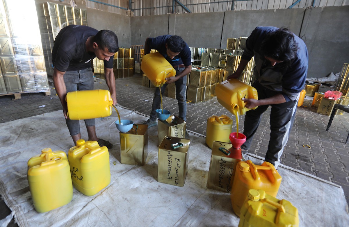 عمال فلسطينيون يجهزون صفائح زيت الزيتون لتصديرها لدول الخليج في مدينة خان يونس جنوب قطاع غزة 4.jpg