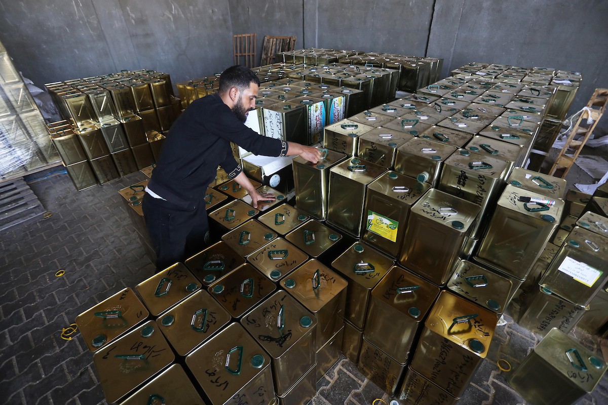 عمال فلسطينيون يجهزون صفائح زيت الزيتون لتصديرها لدول الخليج في مدينة خان يونس جنوب قطاع غزة 10.jpg